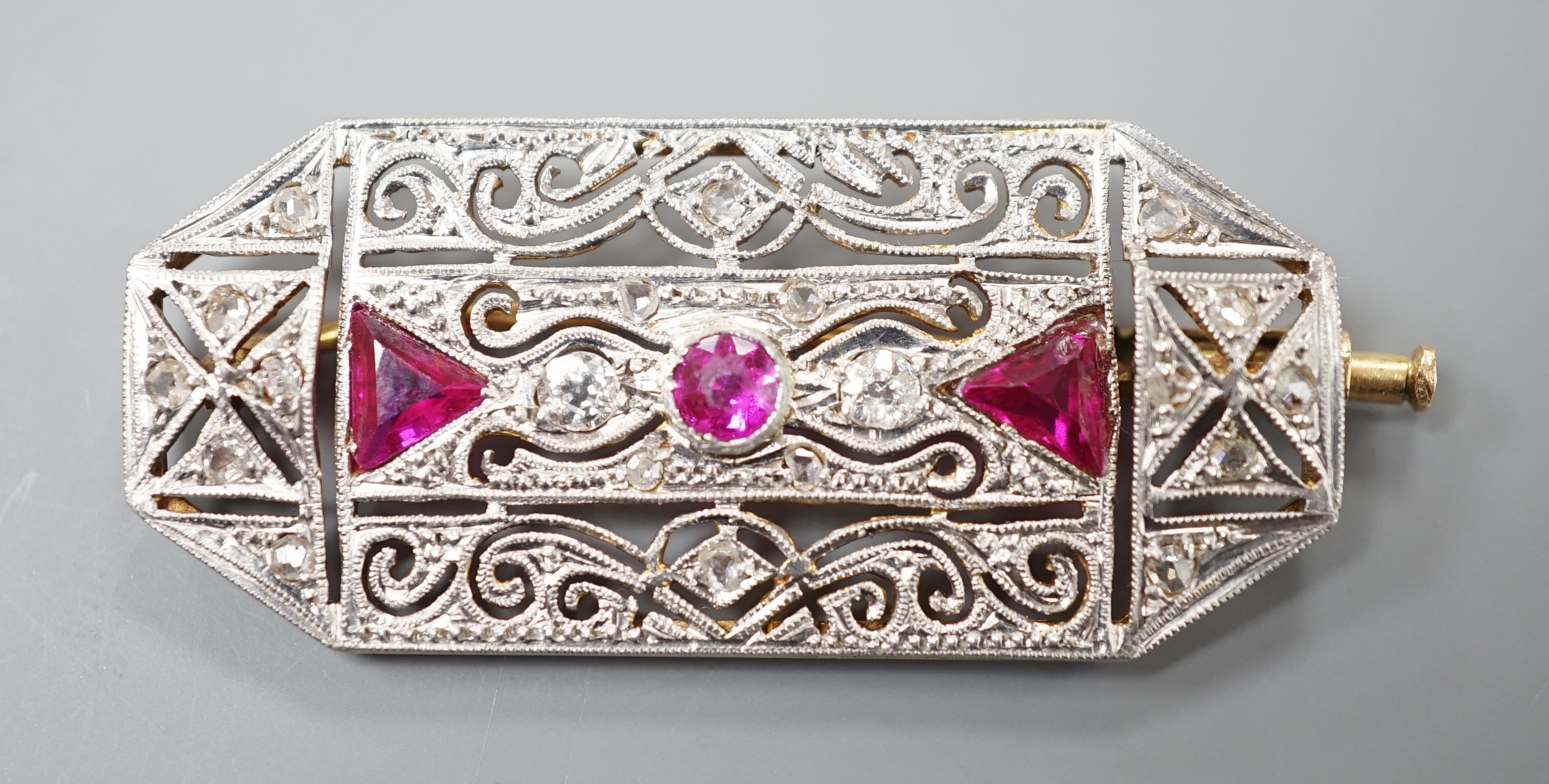 A yellow and white metal, synthetic ruby? and millegrain set diamond octagonal brooch, 40mm, gross weight 7.7 grams.